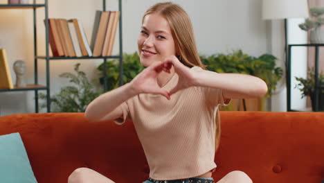 Happy-young-woman-girl-makes-symbol-of-love-showing-heart-sign-to-camera-express-romantic-feelings
