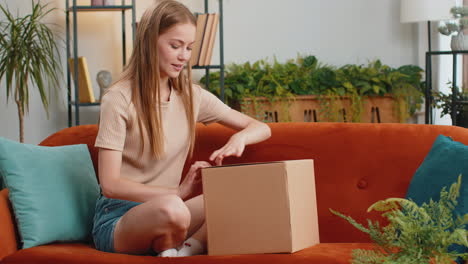 Glückliche-Junge-Käuferin-Packt-Karton-Aus,-Lieferung-Von-Paketen,-Online-Shopping-Kauf-Zu-Hause