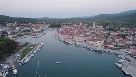 Old-town-and-port-in-popular-tourist-destination-Stari-Grad,-Island-Hvar,-Croatia,-aerial