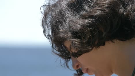 Close-up-of-girl-face-filming-sea-scenery-with-smartphone