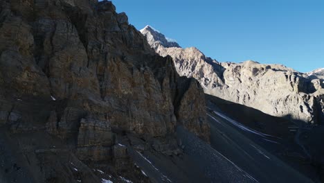 Volando-Sobre-Formaciones-Rocosas-De-Piedra,-Escarpadas-Cadenas-Montañosas-Y-Cielo-Azul-En-Nepal