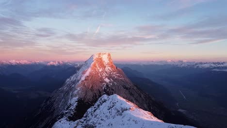 Beautiful-alpine-mountain-peak-top-in-sunset-golden-hour-purple-glow,-valleys-and-snowy-ranges-in-distance
