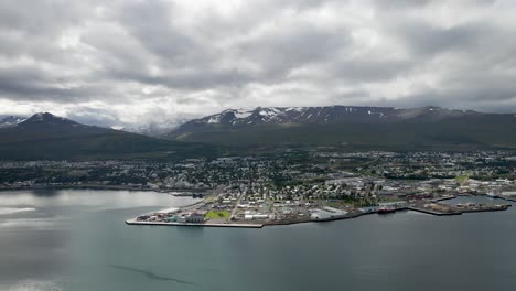 Explore-Akureyri-in-vivid-4K,-an-Icelandic-gem-framed-by-snowy-peaks-and-serene-waters,-captured-by-drone