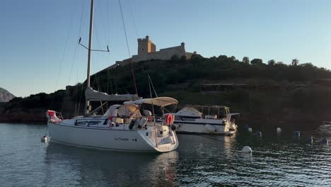Tour-boat-at-Girolata-village-of-Scandola-peninsula-nature-reserve-in-summer-season,-Corsica-island-in-France