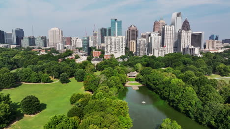 Aerial-slider-of-green-public-park-and-high-rise-office-buildings-in-background