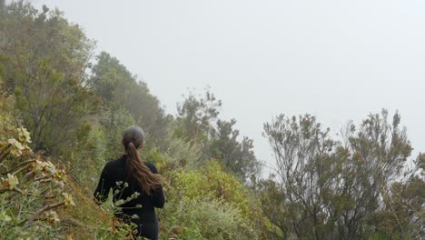 Mujer-Joven-Disfrutando-Del-Clima-Brumoso-En-Las-Montañas-De-Tenerife,-Vista-Posterior