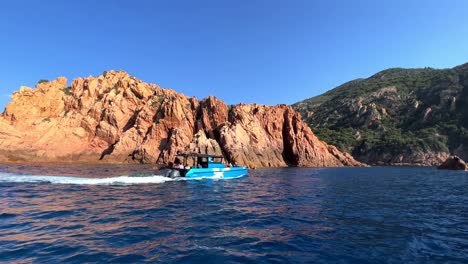 Tour-boat-at-famous-Calanques-de-Piana-volcanic-eroded-rock-formations-in-Corsica-island-in-summer-season,-France
