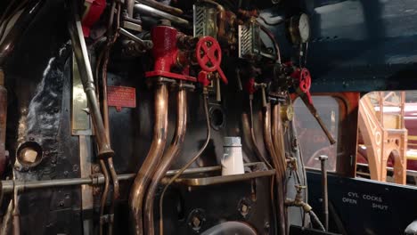 tilting-shot-of-a-drivers-cab-within-a-steam-train-in-The-National-Railway-Museum-In-York