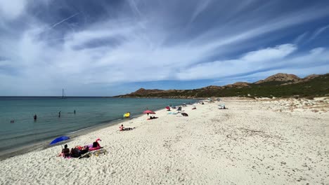 People-bathing-and-sunbathing-on-white-sand-of-Lotu-beach-in-summer-season,-Corsica-island-in-France