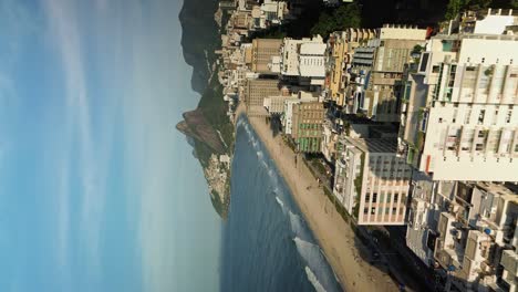Drone-Volando-Sobre-Edificios-De-Varios-Pisos-A-Lo-Largo-De-Una-Playa-De-Arena-En-Río-De-Janeiro---Video-Vertical