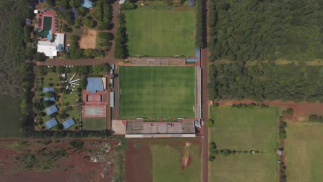 Aerial:-soccer-field,-surrounded-by-greenery-and-buildings,-in-Misiones,-Argentina