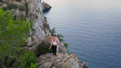 Erstaunliche-Luftaufnahme-Von-Oben-Flug-Ibiza-Cliff-Yoga-Baum-Pose-Modell-Mädchen-Sonnenuntergang-Abend