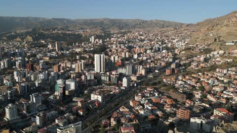 Panoramic-view-of-buildings-along-roadside-in-La-Paz,-Bolivia-with-mountains-in-the-background-on-a-sunny-day