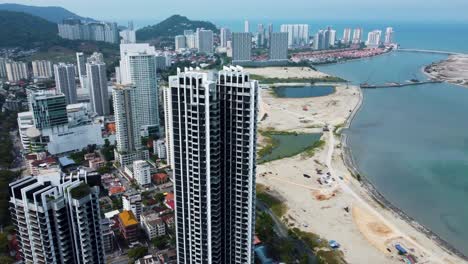 Along-the-Penang-city-coastline-of-splendid-tall-structures,-aerial