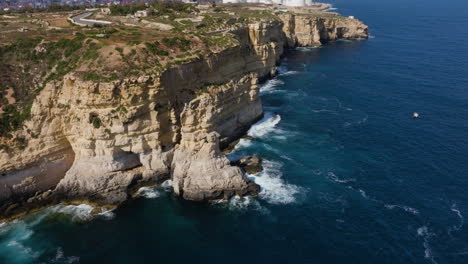 Drone-shot-circling-the-high-sea-coast,-golden-hour-on-the-Malta-island