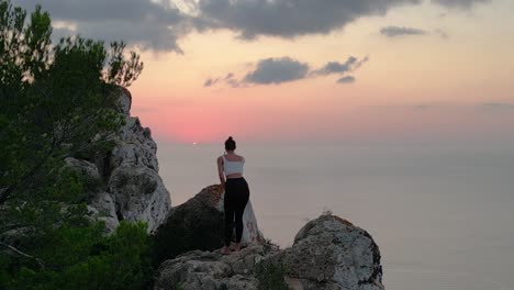Spectacular-aerial-top-view-flight-Ibiza-cliff-dancing-model-girl-sunset-evening