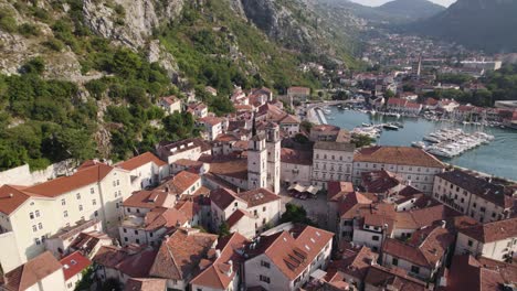 Drone-flight-over-Kotor-Old-Town-with-marina-in-background,-Montenegro