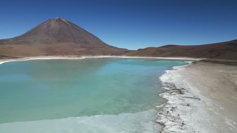 Luftdrohnenschwenkaufnahme-Von-Rechts-Nach-Links-über-Einem-Großen,-Teilweise-Zugefrorenen-See-Am-Fuße-Eines-Berges-In-Bolivien-An-Einem-Kalten-Wintertag