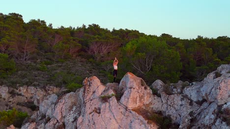 Glatte-Luftaufnahme-Von-Oben-Flug-Ibiza-Klippe-Yoga-Baum-Pose-Modell-Mädchen-Sonnenuntergang-Abend