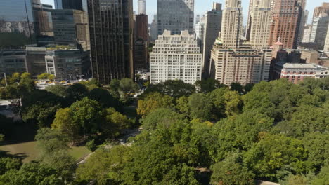 Central-park-with-the-Upper-east-side-skyline-background,-in-sunny-NY---Aerial-view