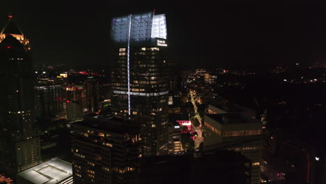 Fly-around-modern-high-rise-office-buildings-in-metropolis-at-night