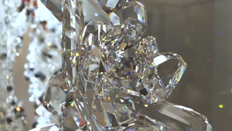 4k-orbit-around-sparkling-crystal-sculpture-with-bright-colorful-lights-reflecting-on-it-with-more-crystals-in-the-background-visible-while-moving