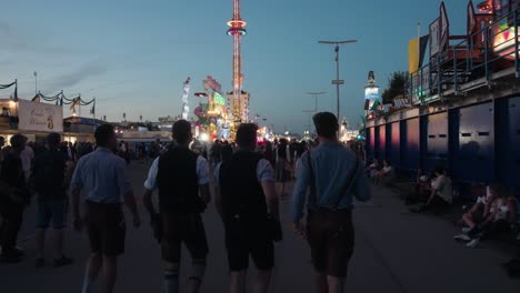 Rear-view-following-group-of-young-men-in-white-shirts-and-vests-posing-with-girls-at-festival