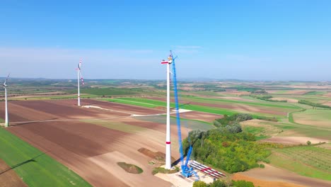 Wind-Turbine-Under-Construction-In-Agricultural-Landscape---aerial-drone-shot