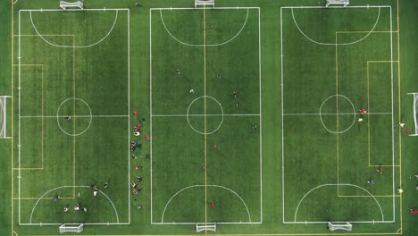 birds-eye-view-shot-of-many-young-adults-playing-football-and-trying-to-win-on-a-hot-and-clear-summers-day-in-england