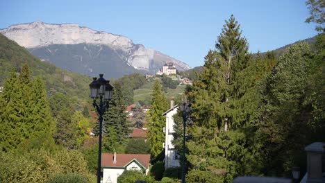 Castillo-De-Annecy-Cheetah-En-El-Pueblo-Francés-Alpino-Con-Casas-Y-Montañas,-Plano-Lejano