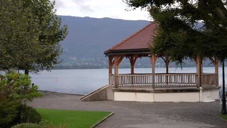 Large-Gazebo-at-Lake-Annecy-shore-in-the-French-Alps,-Medium-stable-shot