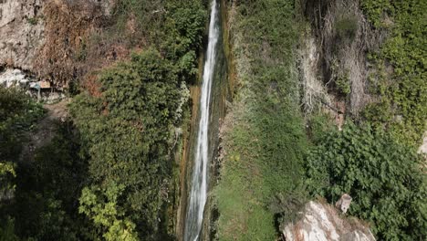 Narrow-waterfall-in-Spain,-aerial-ascend-view