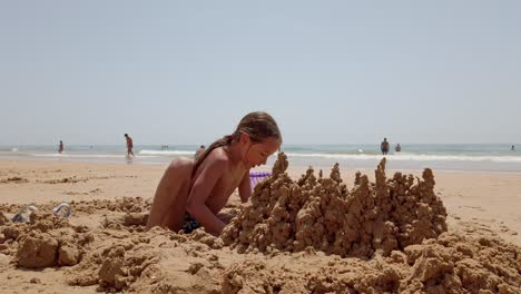 Praia-Da-Rocha-Baixinha,-Portugal---Ein-Junges-Mädchen-Baut-Sandburgen-Am-Strand---Nahaufnahme