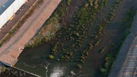 Santa-Fe-dam-flood-controlling-runoff-after-heavy-rain-on-a-foggy-morning---aerial-tilt-up-reveal