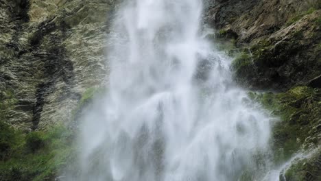 Majestic-tall-waterfall-stream-crashing-onto-rocky-cliff,-closeup