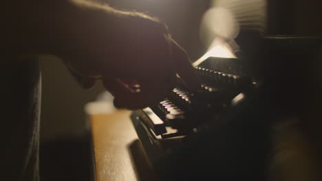 Nahaufnahme-Einer-Person,-Die-Auf-Einer-Alten-Schreibmaschine-Tippt,-Verträumte-Szene-Mit-Hintergrundbeleuchtung