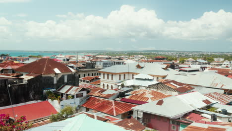 Rustic-rooftops-of-Stone-Town,-Zanzibar,-with-ocean-backdrop