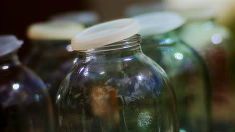 Makro-Leerer-Glasflaschen-Mit-Plastikdeckeln,-Die-Auf-Apfelsaft-Warten