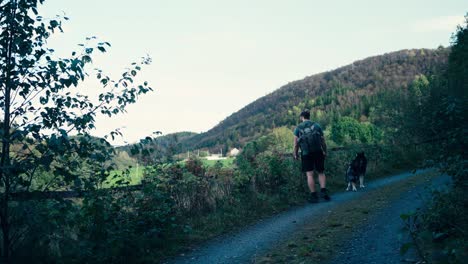 Indre-Fosen,-Norwegen-–-Ein-Mann-Und-Sein-Hund-Machen-Einen-Gemütlichen-Spaziergang-Entlang-Einer-Pilgerroute-An-Der-Küste-–-Statische-Aufnahme