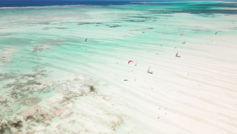 Aerial-view-of-kitesurfers-gliding-over-turquoise-waters