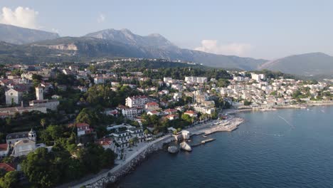 Herceg-Novi-scenic-coastal-town-aerial-view-circling-bay-of-Kotor-at-the-foot-of-mount-Orjen,-Montenegro-mountain-range