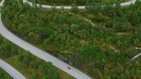 Luftaufnahmen-Entlang-Einer-Kurvenreichen-Straße-Mit-Einem-Einsamen-Roten-Auto-In-Der-Nähe-Von-Hjelledalen,-Norwegen