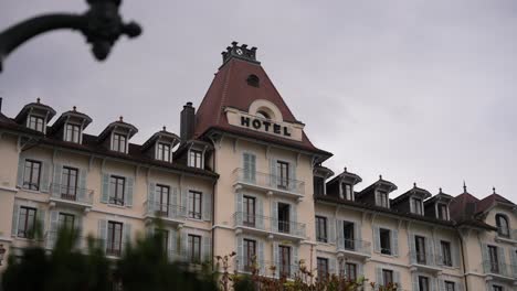 Palace-de-Menthon-luxury-hotel-façade-in-the-Alps,-Wide-handheld-shot
