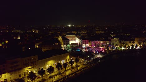 Aerial-view-descending-towards-illuminated-Split-cityscape-nightlife-and-waterfront-in-Croatia