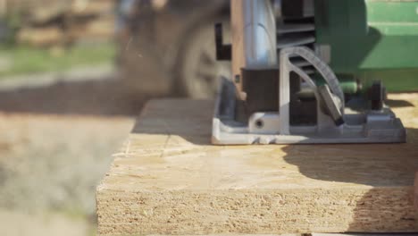 Handheld-circular-saw-cutting-oriented-strand-board-on-construction-site