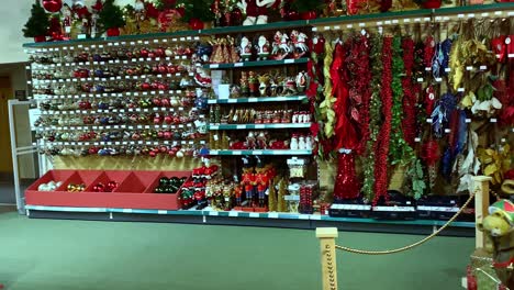 Shelves-full-of-tinsel,-baubles,-tree-decorations-with-a-full-size-Santa-Claus-model-as-well-at-the-Leicestershire-county-garden-centre-Christmas-shop
