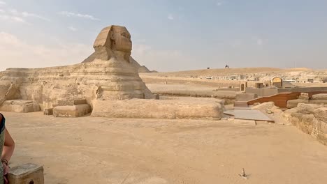 Pan-across-iconic-sphinx-in-egypt-at-midday,-historic-excavation-site-of-a-grand-wonder