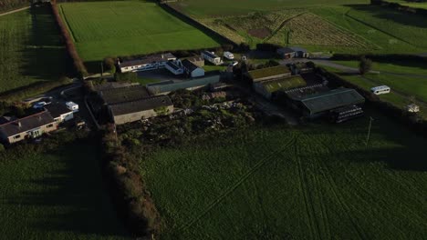 Luftaufnahme-Mit-Blick-Auf-Den-Kleinen-Landwirtschaftlichen-Betrieb-Des-Dorfes-Anglesey,-Der-Lebendige-Landwirtschaftliche-Nutzflächen-Offenbart