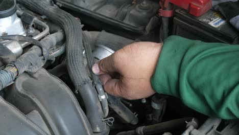 Ein-Automechaniker,-Der-An-Einem-Alten-Motor-Arbeitet-Und-Mit-Seinen-Händen-Eine-Drosselklappe-Repariert
