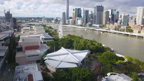 Aerial-flying-backwards-from-South-Bank-Parklands,-Brisbane-CBD-in-background